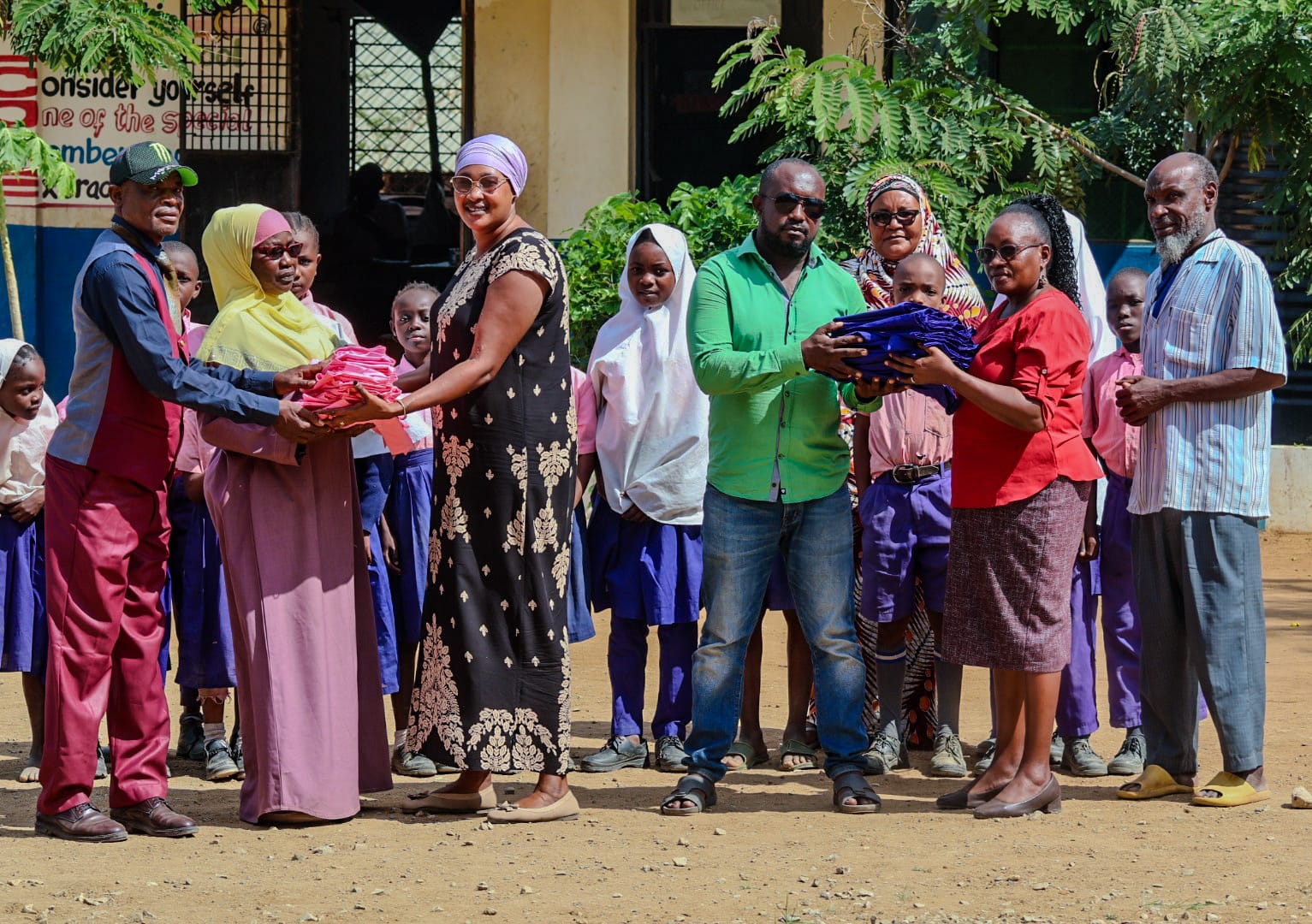 Foundation representatives handing over school uniforms to community members